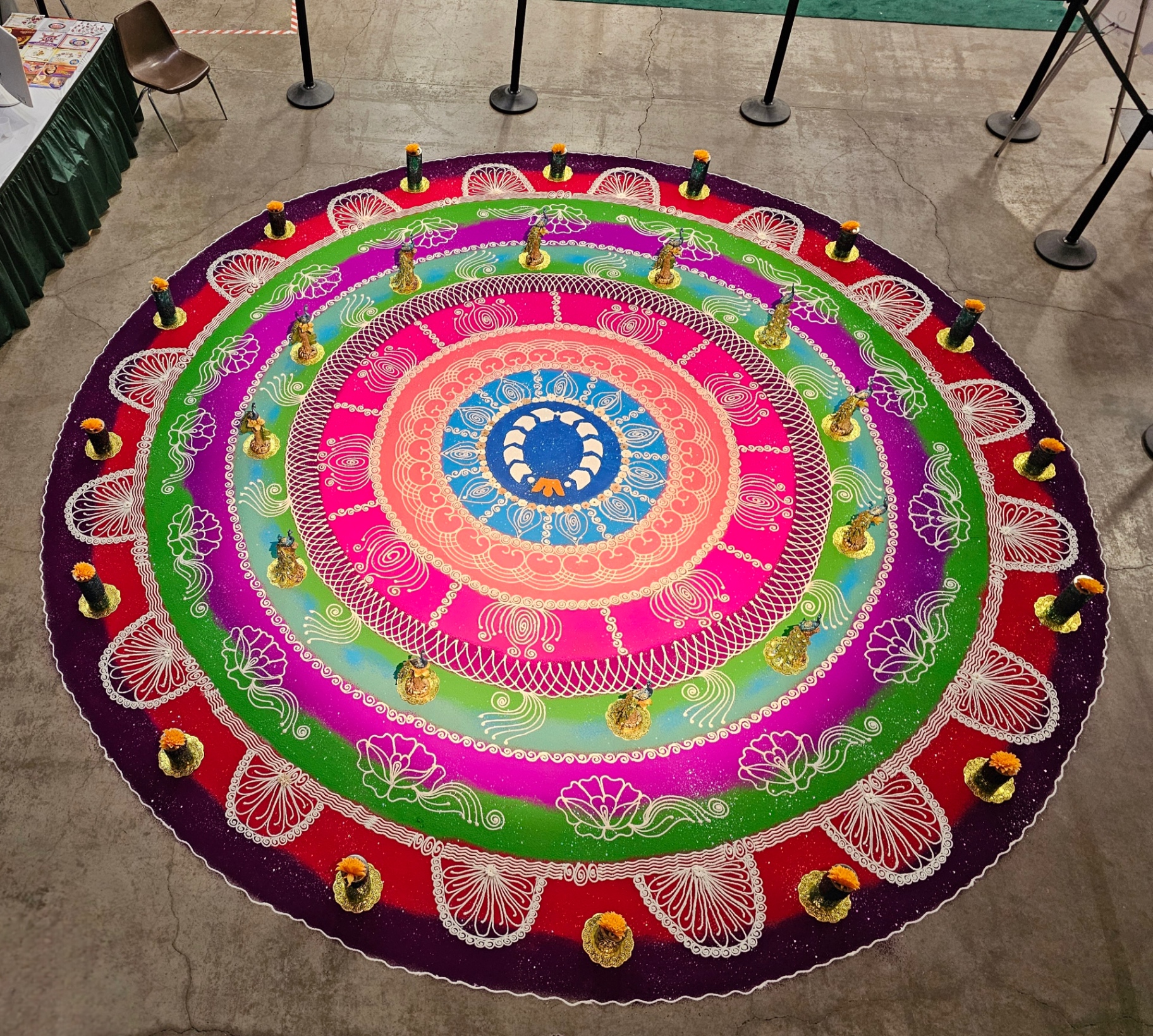 Large circular rangoli surrounded by lit diyas